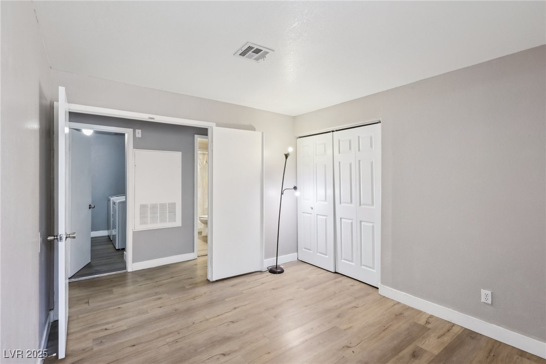 5241 South Lindell Road, Unit 202 Las Vegas, NV 89118 - Photo 30 of 35 Unfurnished bedroom featuring a closet, baseboards, visible vents, and light wood finished floors