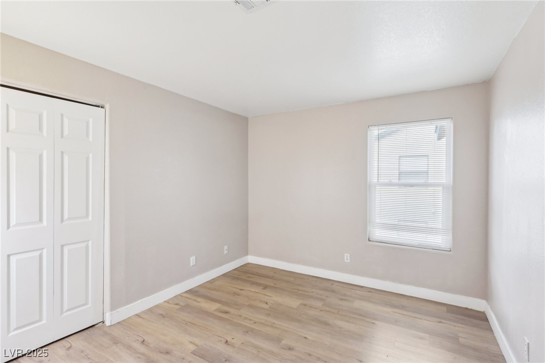 5241 South Lindell Road, Unit 202 Las Vegas, NV 89118 - Photo 31 of 35 Unfurnished bedroom featuring a closet, baseboards, and light wood finished floors