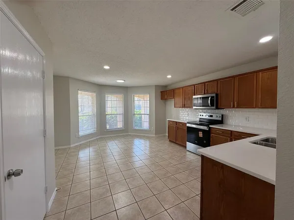 a kitchen with stainless steel appliances granite countertop a sink and stove top oven with wooden floor