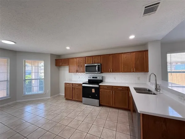a large kitchen with stainless steel appliances granite countertop a sink and cabinets