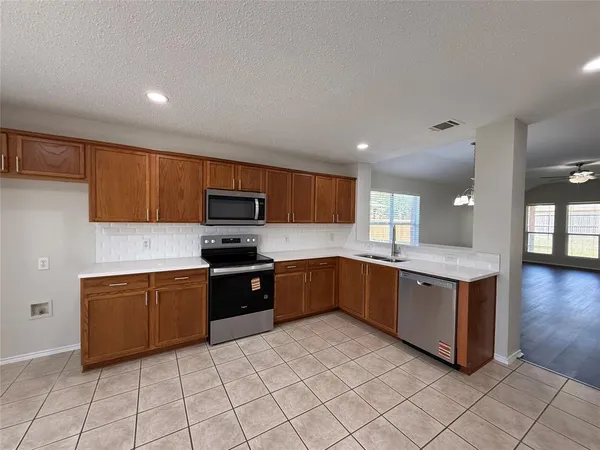 a large kitchen with a large counter top and stainless steel appliances