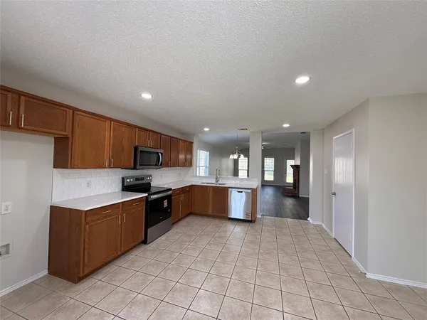 a kitchen with stainless steel appliances granite countertop a refrigerator and a stove top oven