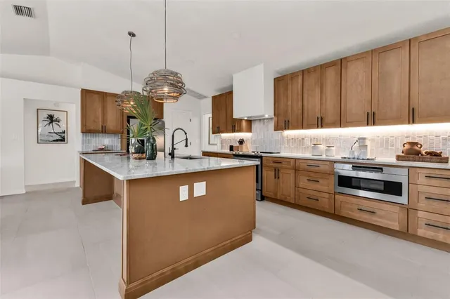 a kitchen with stainless steel appliances granite countertop a sink a stove and a refrigerator