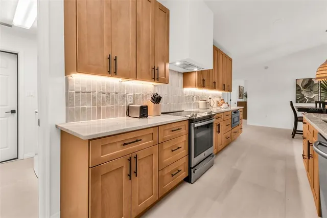 a kitchen with stainless steel appliances granite countertop a sink stove and refrigerator