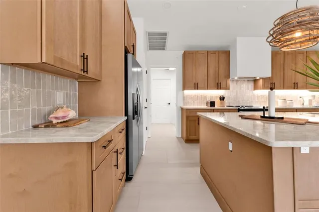 a kitchen with stainless steel appliances granite countertop a sink a stove and a wooden floors