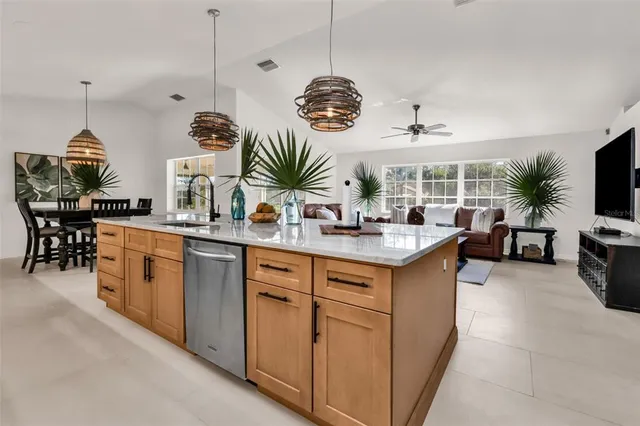 a kitchen with stainless steel appliances granite countertop a sink a stove and a wooden floors