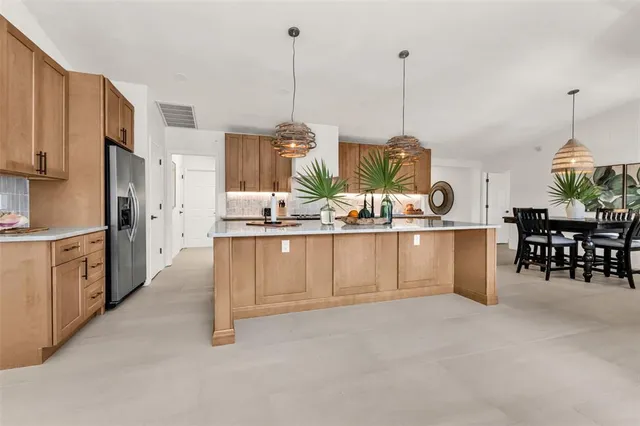 a kitchen with stainless steel appliances kitchen island granite countertop a stove a sink and a refrigerator