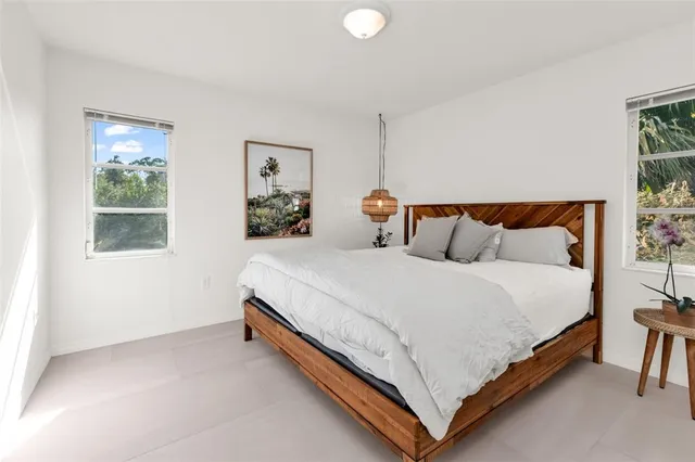 a bedroom with a bed and painting on the wall