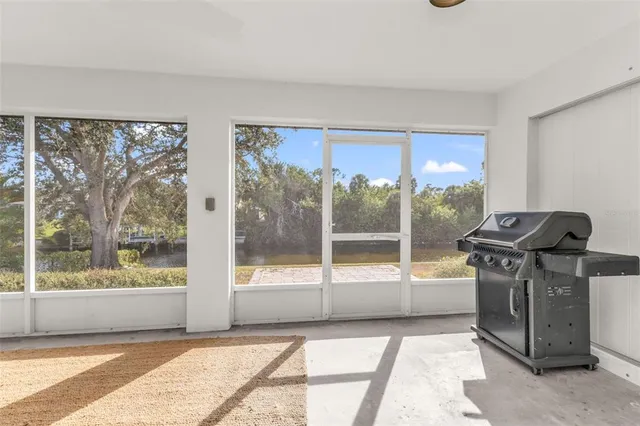 a living room with a floor to ceiling window and wooden floor
