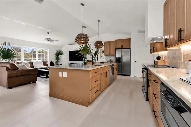 a kitchen with kitchen island granite countertop a sink cabinets and window
