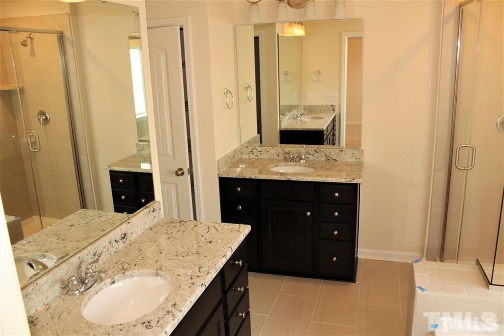 2102 Peakside Drive Apex, NC 27523 - Photo 11 of 21 a bathroom with a granite countertop sink a mirror and shower