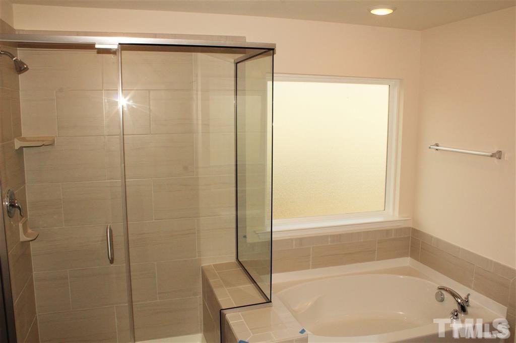 2102 Peakside Drive Apex, NC 27523 - Photo 12 of 21 a bathroom with a shower and a bath tub