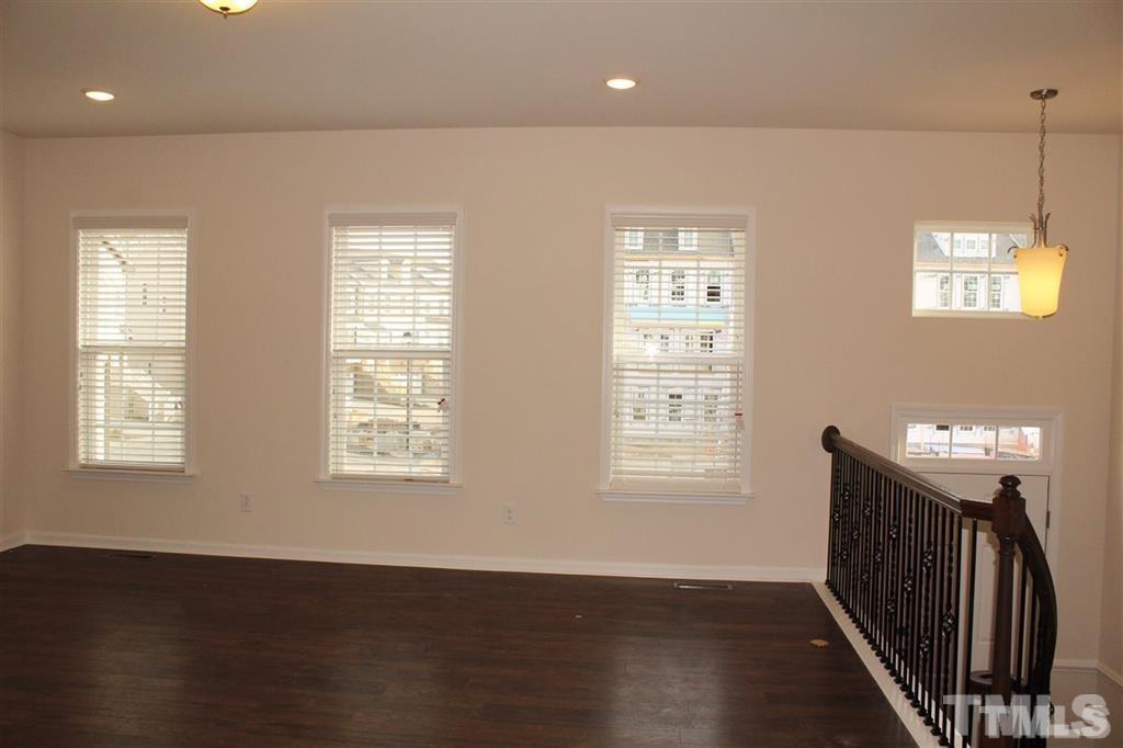 2102 Peakside Drive Apex, NC 27523 - Photo 5 of 21 a view of an empty room with wooden floor and a window