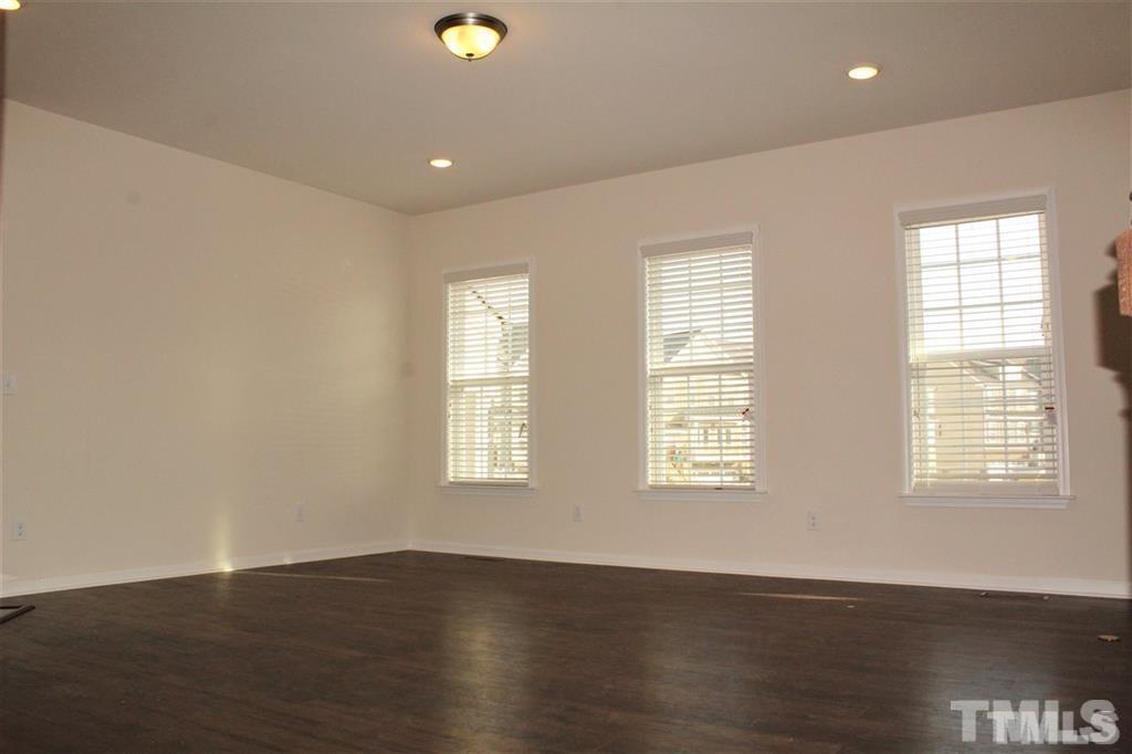 2102 Peakside Drive Apex, NC 27523 - Photo 6 of 21 a view of an empty room with wooden floor and windows