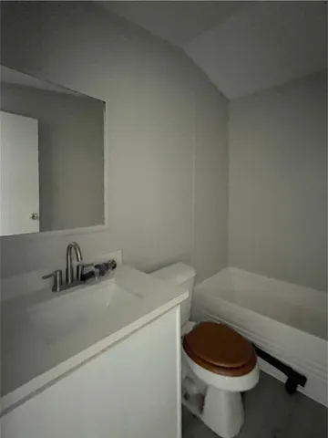 a bathroom with a sink a toilet and a mirror