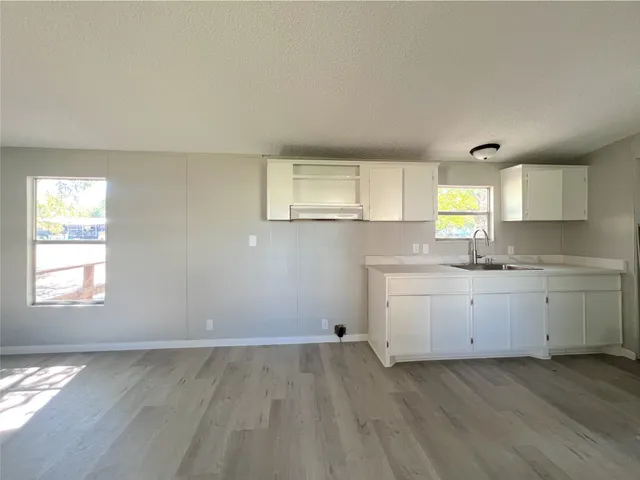 a view of a kitchen with wooden floor and electronic appliances