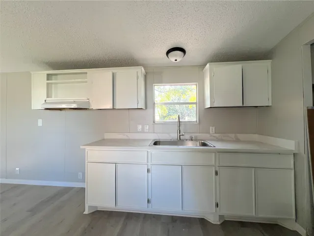 a kitchen with white cabinets appliances a sink and dishwasher