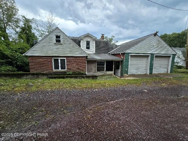 a view of a house with yard and a large tree