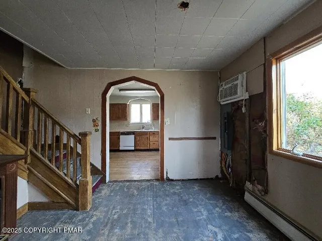 a view of an empty room with wooden floor a fireplace