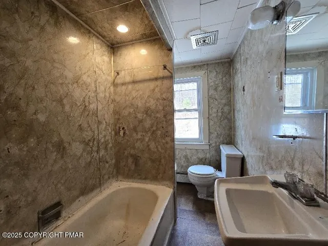 a bathroom with a tub a sink and a large window