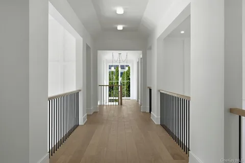 a view of a hallway with wooden floor and windows