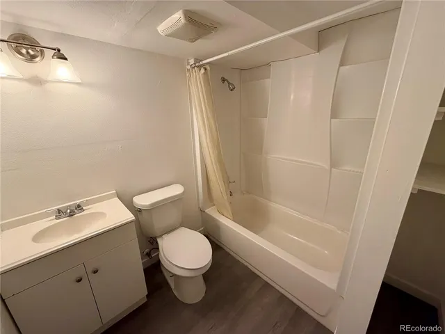 a white toilet sitting next to a bath tub