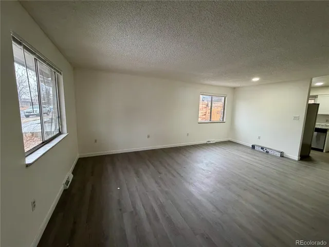 a view of a room with wooden floor and window