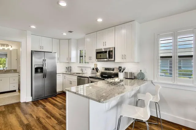 a kitchen with stainless steel appliances granite countertop a refrigerator sink and microwave