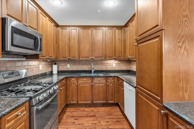 a kitchen with stainless steel appliances a stove a sink and a microwave