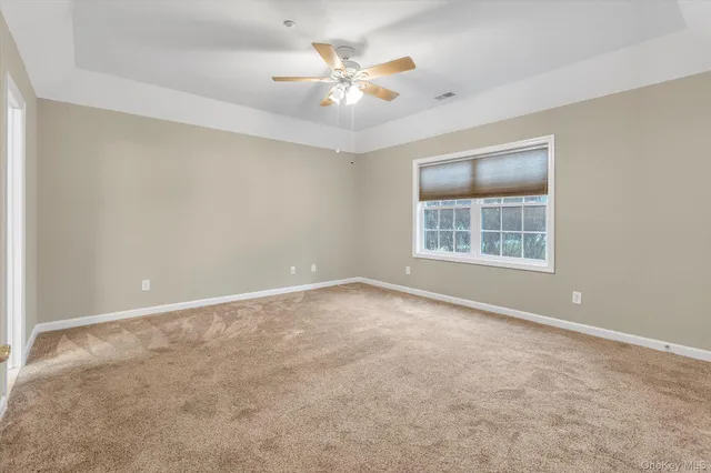 an empty room with windows and chandelier fan