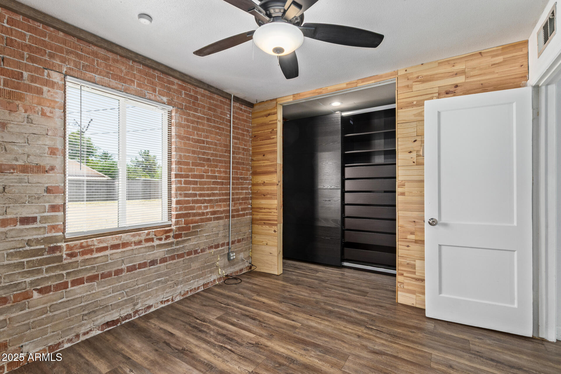 2615 North 29th Place Phoenix, AZ 85008 - Photo 12 of 26 a view of empty room with wooden floor and fan