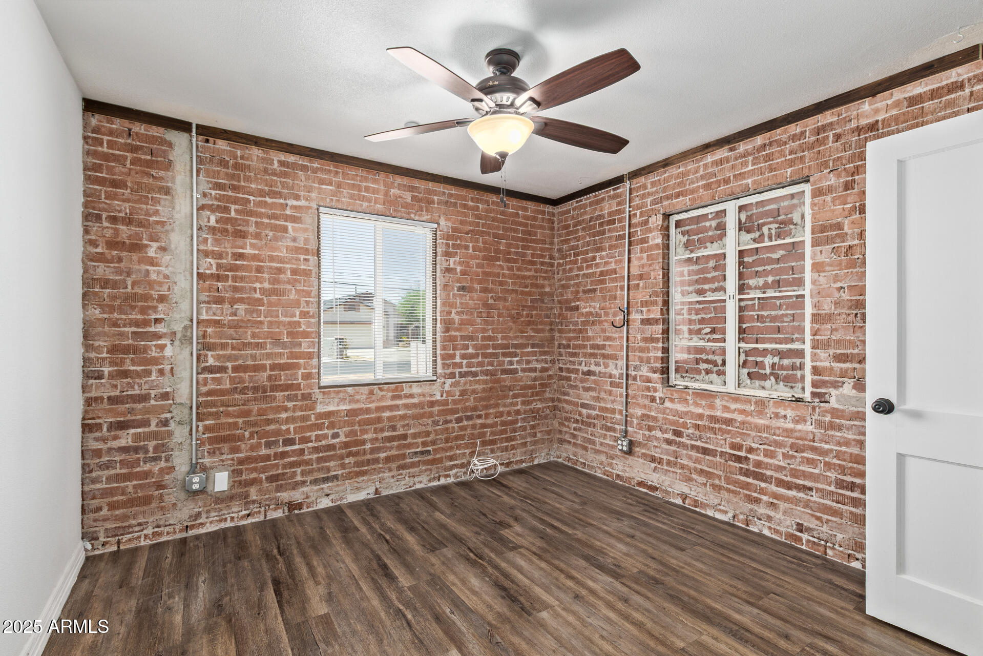 2615 North 29th Place Phoenix, AZ 85008 - Photo 13 of 26 a view of an empty room with wooden floor and a window