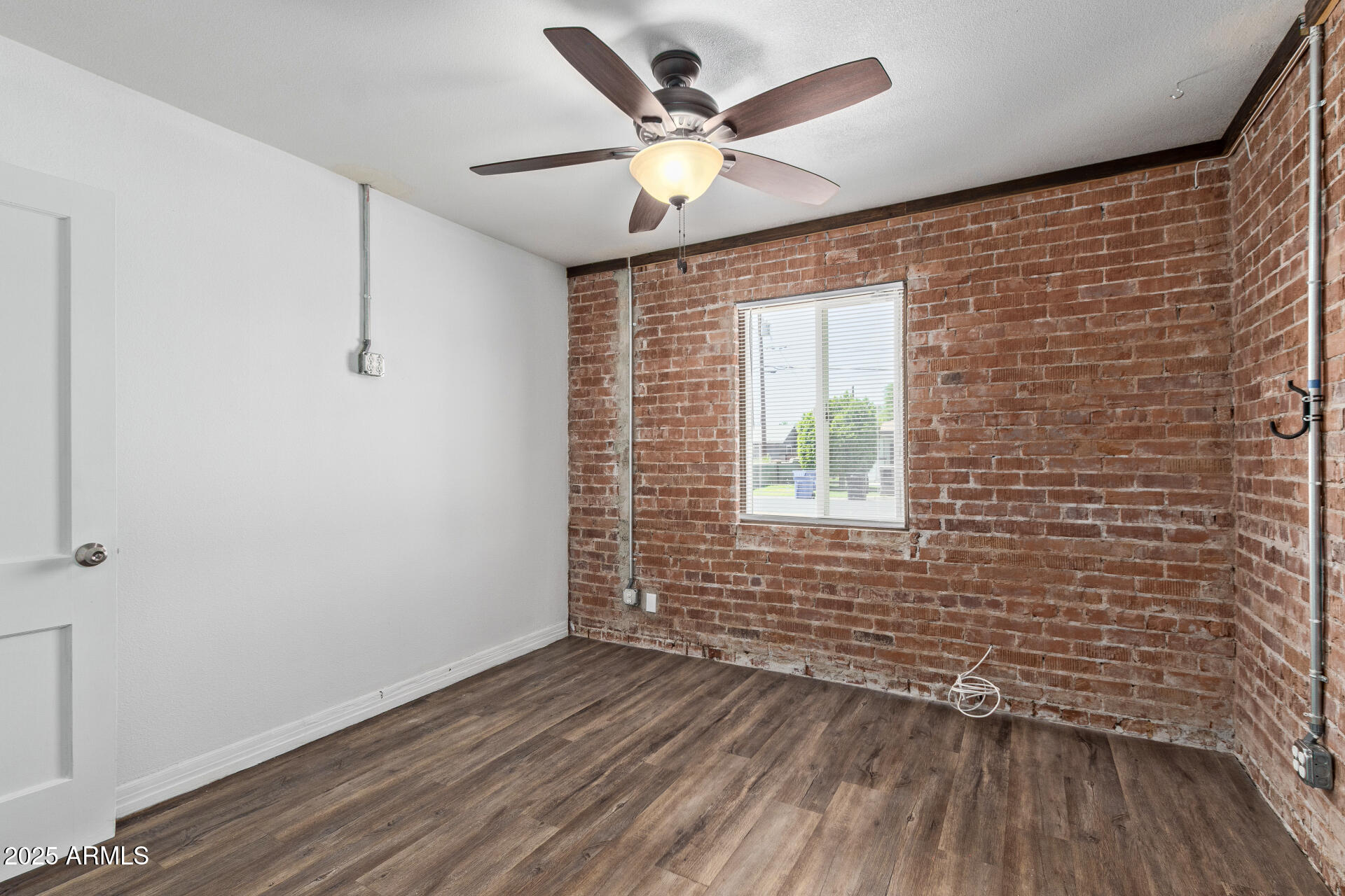 2615 North 29th Place Phoenix, AZ 85008 - Photo 16 of 26 a view of an empty room with wooden floor and a window