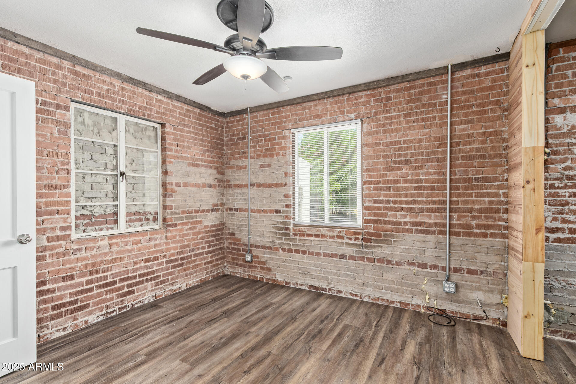 2615 North 29th Place Phoenix, AZ 85008 - Photo 17 of 26 a view of empty room with wooden floor and fan