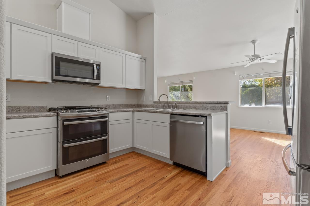 17040 Castle Pine Drive Reno, NV 89511 - Photo 11 of 31 a kitchen with granite countertop wooden floors and stainless steel appliances