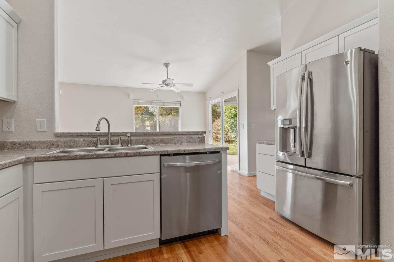 17040 Castle Pine Drive Reno, NV 89511 - Photo 12 of 31 a kitchen with granite countertop a refrigerator and a sink