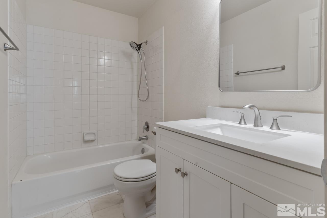 17040 Castle Pine Drive Reno, NV 89511 - Photo 23 of 31 a bathroom with a granite countertop sink a toilet and shower