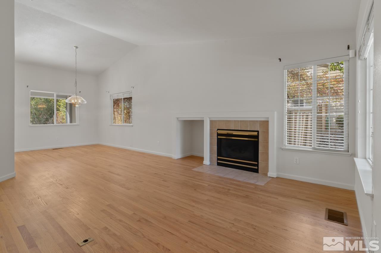 17040 Castle Pine Drive Reno, NV 89511 - Photo 5 of 31 a view of empty room with a fireplace and wooden floor