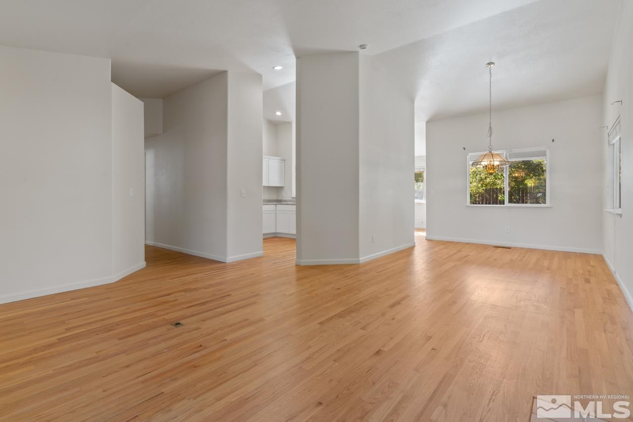 17040 Castle Pine Drive Reno, NV 89511 - Photo 6 of 31 an empty room with wooden floor and chandelier