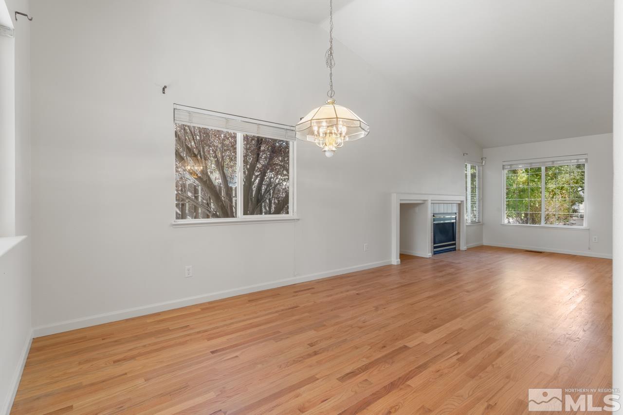 17040 Castle Pine Drive Reno, NV 89511 - Photo 7 of 31 an empty room with wooden floor chandelier and windows
