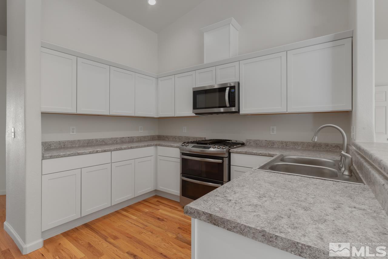 17040 Castle Pine Drive Reno, NV 89511 - Photo 10 of 31 a kitchen with granite countertop a sink and a stove top oven