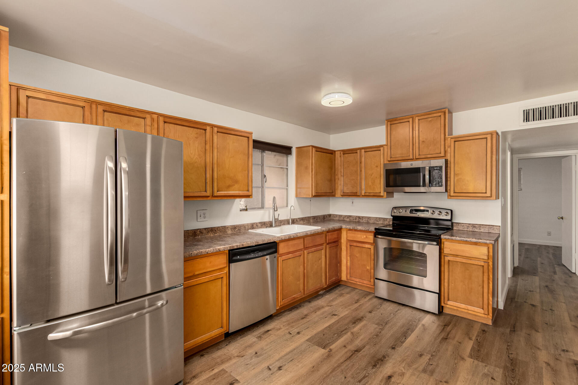 3540 East Montecito Avenue, Unit 1 Phoenix, AZ 85018 - Photo 11 of 26 a kitchen with stainless steel appliances granite countertop a refrigerator stove microwave and sink