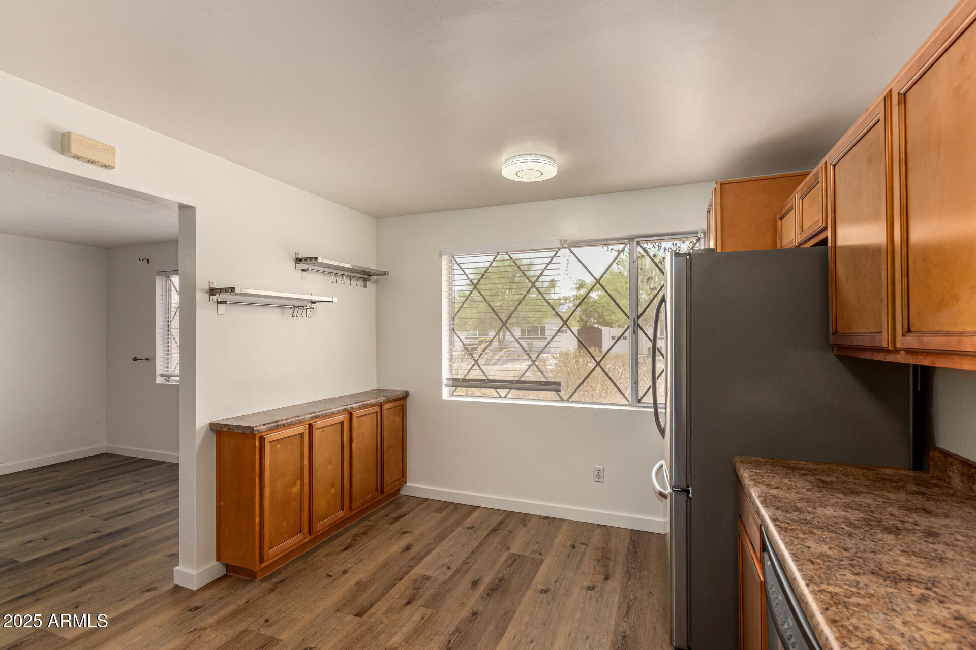 3540 East Montecito Avenue, Unit 1 Phoenix, AZ 85018 - Photo 13 of 26 a view of an empty room with wooden floor and a window