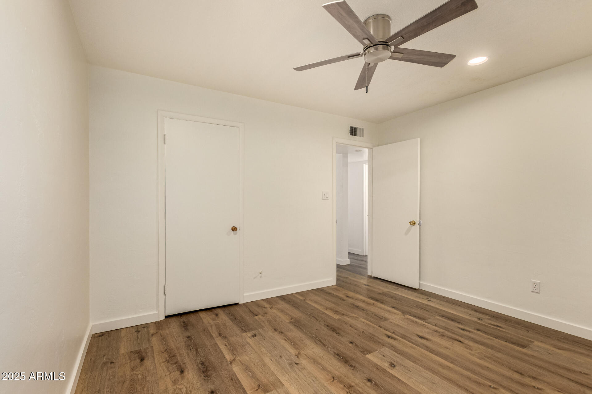 3540 East Montecito Avenue, Unit 1 Phoenix, AZ 85018 - Photo 19 of 26 an empty room with wooden floor and ceiling fan