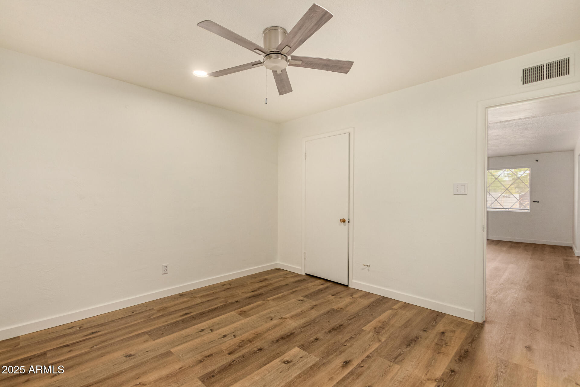 3540 East Montecito Avenue, Unit 1 Phoenix, AZ 85018 - Photo 20 of 26 an empty room with wooden floor and ceiling fan