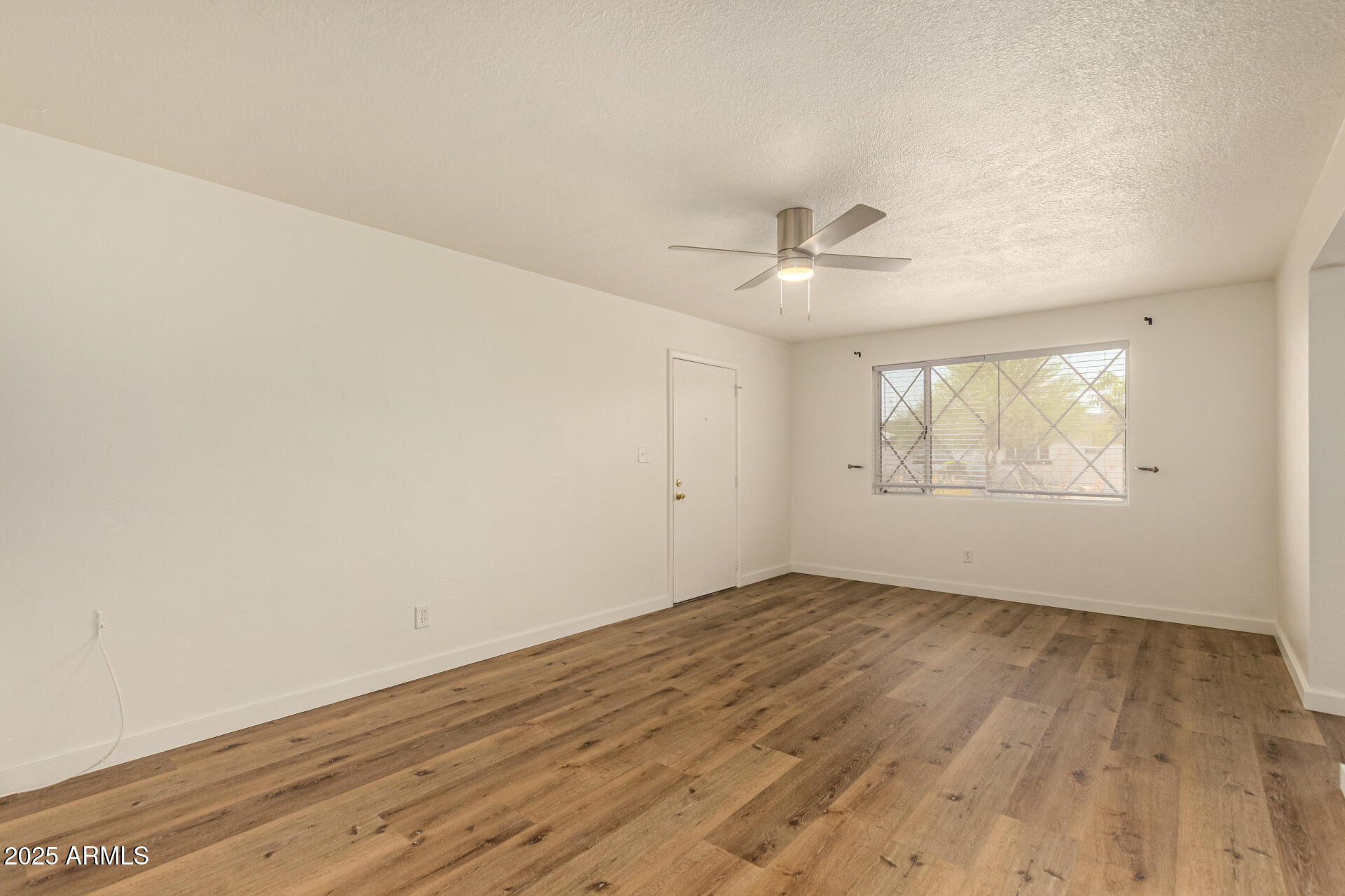 3540 East Montecito Avenue, Unit 1 Phoenix, AZ 85018 - Photo 7 of 26 an empty room with wooden floor and windows