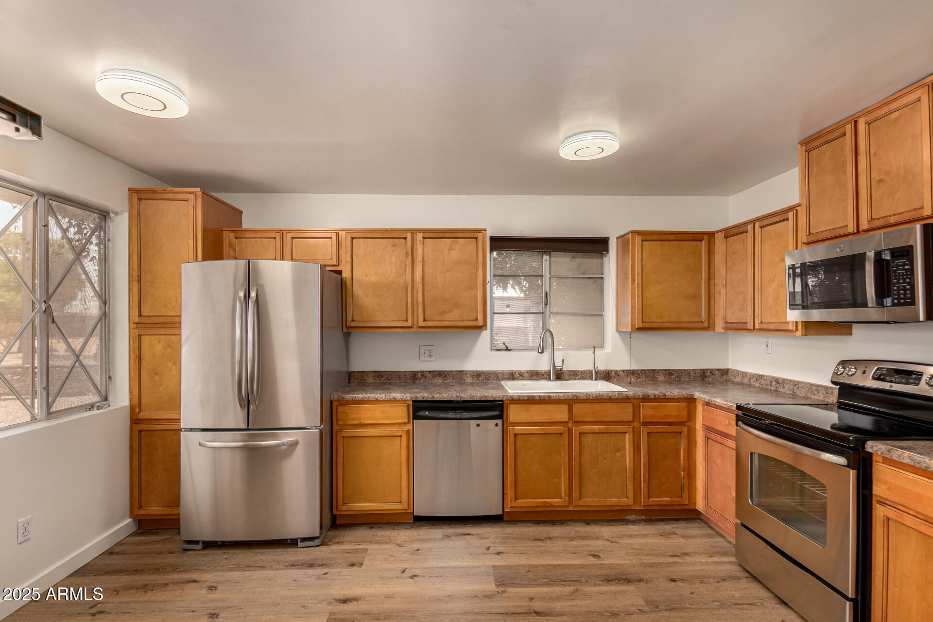 3540 East Montecito Avenue, Unit 1 Phoenix, AZ 85018 - Photo 10 of 26 a kitchen with stainless steel appliances a refrigerator stove microwave and sink