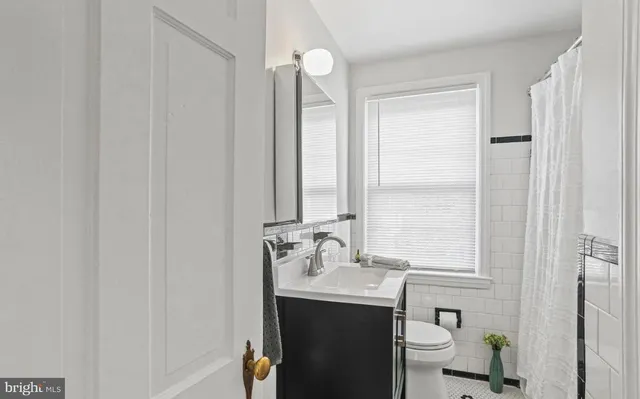 a bathroom with a sink vanity mirror and toilet