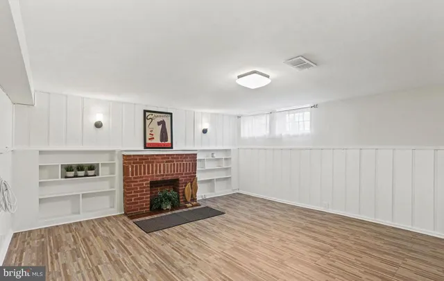 a view of a livingroom with a fireplace wooden floor and windows