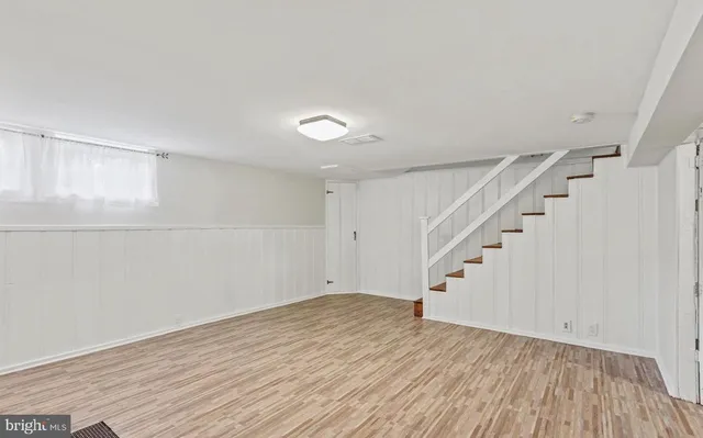 a view of an empty room with wooden floor and entryway